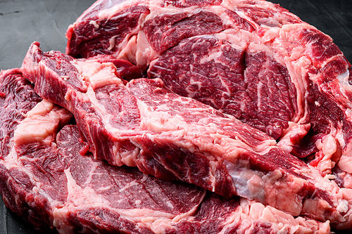 Rib eye steak of beef marbled meat or scotch fillet set, on black stone background, top view flat lay