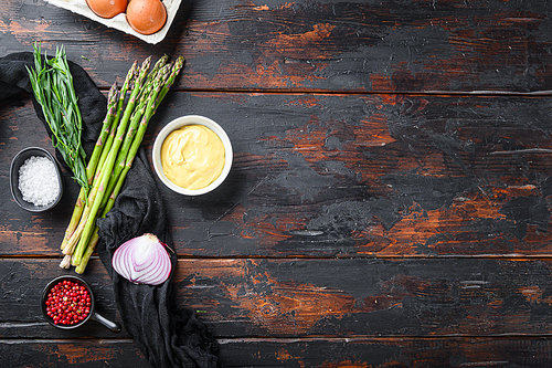 Fresh asparagus eggs and french dressing ingredients with dijon mustard, onion taragon on dark wooden old background, top view with space for text