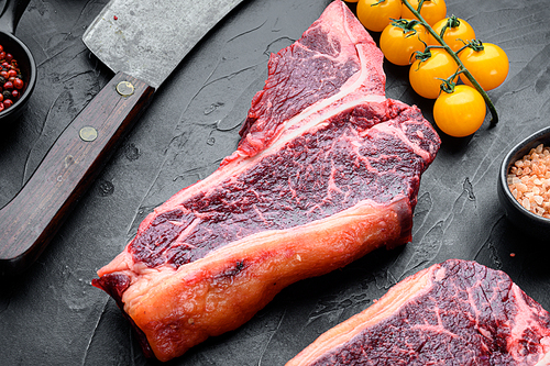 Dry-aged Raw T-bone or porterhouse beef meat Steak set, on black stone background