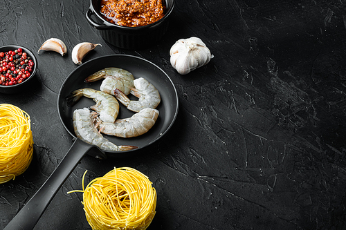 Traditional Italian dish. pasta with pesto ricotta parmesan and grilled seafood ingredients set, on black stone background, with copy space for text