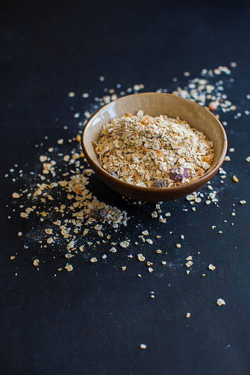 Healthy food concept with oatmeal on dark rustic background with copyspace