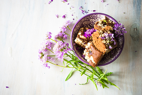 German kuchen chocolate dessert and wild summer purple flowers on a rustic white table