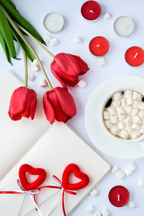 Mock up with empty space for text. Red tulips candles White cup of coffee morning breakfast. Holiday background. Greeting card. Valentines Womans Mothers day. Top view. Flat lay