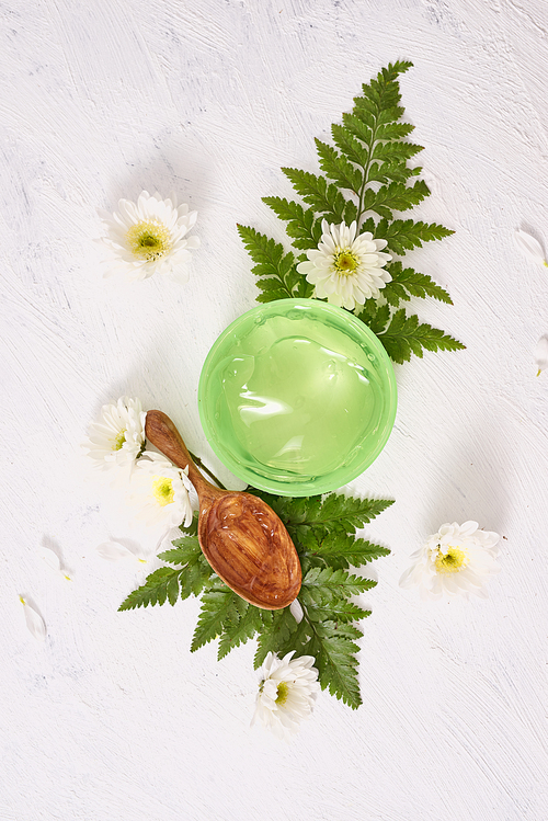 spa setting with cosmetic gel, leaves on white table background