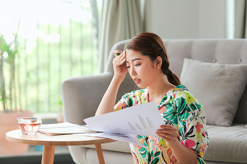 Asian young woman doing work in living room