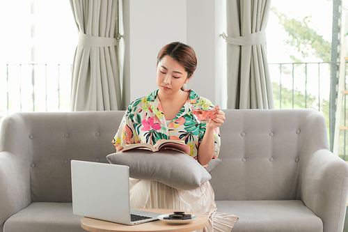 Woman reading book with cup of coffee at home in the living room