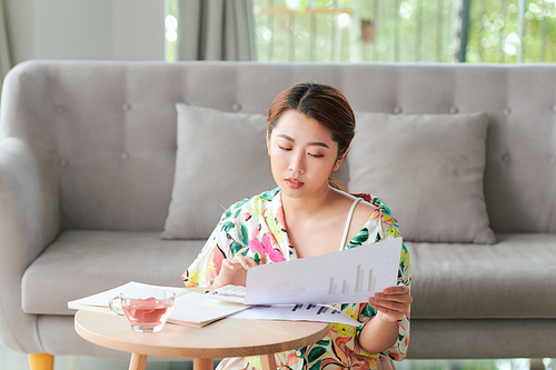 Closeup portrait of attractive young businesslady doing paperwork