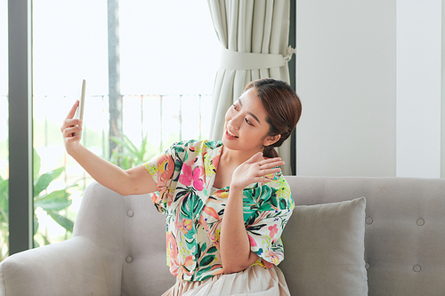 Happy girl waving hand using smartphone app enjoying online virtual chat video call with friends