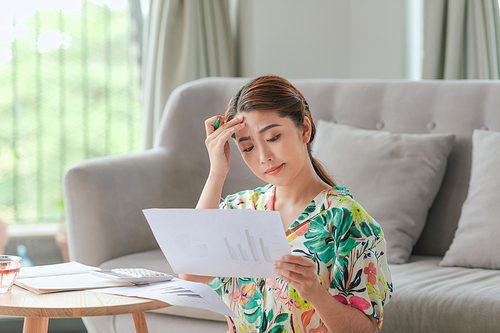 Asian young woman doing work in living room