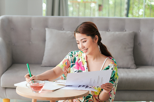 Portrait of an attractive young student doing her homework at hom