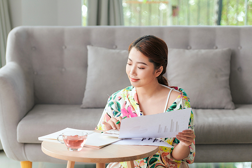 smiling asian female freelancer working at home