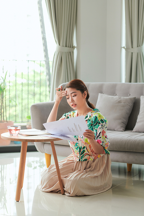 Pleased student girl  doing homework while sitting on floor at home