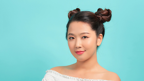 Portrait of beautiful young Asian woman on blue background