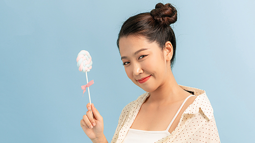 Beautiful model with smile and bright light with candy lollipop