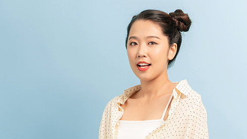 Portrait of beautiful young Asian woman on blue background