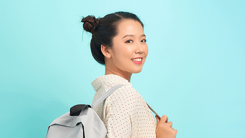 Young woman over isolated blue background with backpack