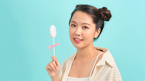 Portrait of a beautiful young attractive girl holding a sucking candy lollipop.