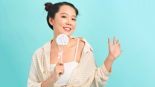 Beautiful model with smile and bright light with candy lollipop