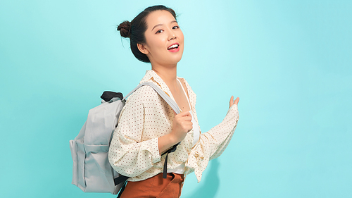 Happy smiling young cute blonde student girl with backpack. Beautiful woman tourist. Study or travel