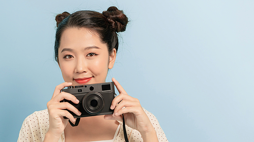 Woman traveler with a camera, blue background