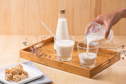 Dairy products. A bottle of milk and glass of milk serve with almond candies on a wooden table.