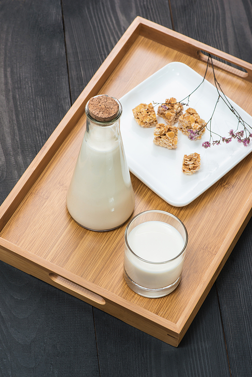 Dairy products. A bottle of milk and glass of milk serve with almond candies on a rustic wooden table.