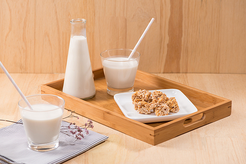 Dairy products. A bottle of milk and glass of milk serve with almond candies on a wooden table.