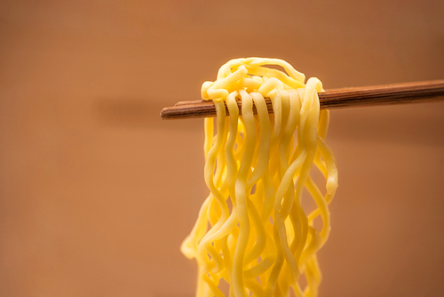 Eating Instant noodles with a wooden chopstick.