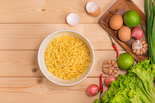 Instant noodles in bowl on wood background