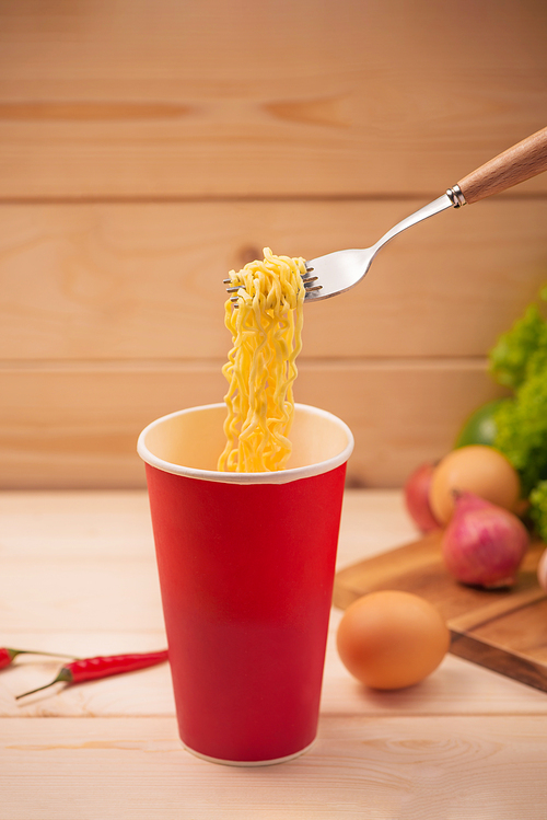 Eating Instant noodles in cup with a fork