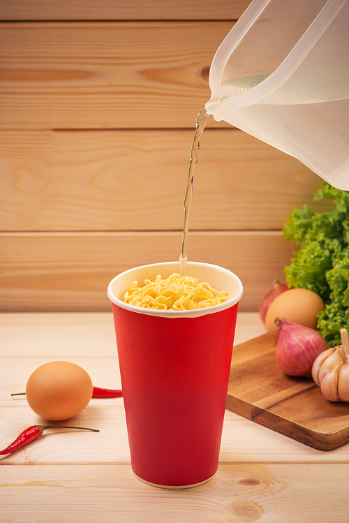 Cooking instant noodles in cup, boiling water.