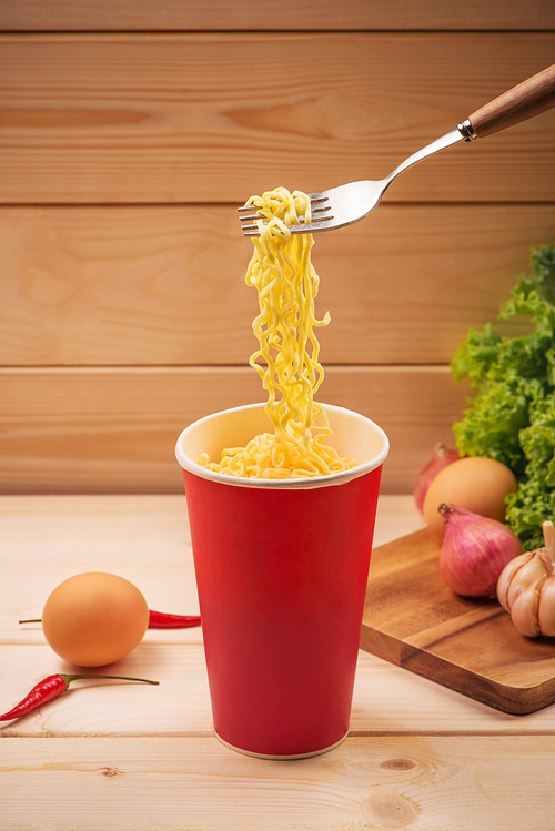 Eating Instant noodles in cup with a fork