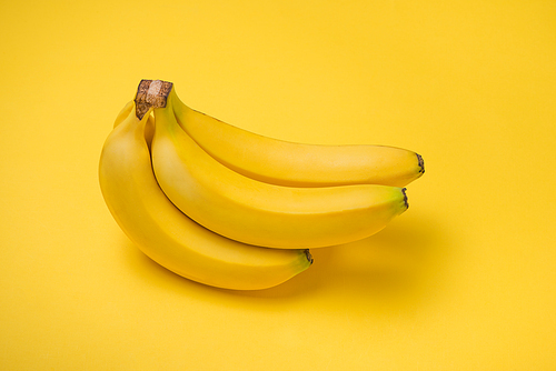 A banch of bananas on yellow background.