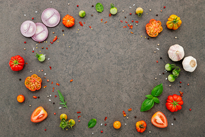 The ingredients for homemade pizza set up on dark stone background.