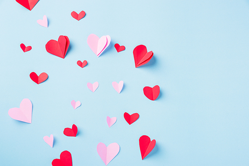 Valentines' day background. Pattern beautiful red paper hearts cut composition greeting card isolated on blue background with copy space, Symbol of love Top View from above