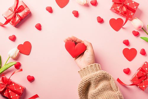 Valentine's day and birthday. Woman hands holding red heart and have gift or present box decorated surprise on pink background, Female's hand hold heart have gift box package in craft paper