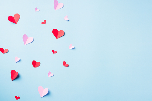 Valentines' day background. Pattern beautiful red paper hearts cut composition greeting card isolated on blue background with copy space, Symbol of love Top View from above