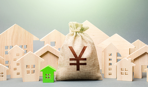 Yen Yuan money bag and a city of house figures. Buying real estate, fair price. City municipal budget. Development and renovation of buildings. Investments. Cost of living in town. Property tax.