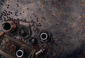 Turkish coffee pot, cups and grinding on dark rustic background