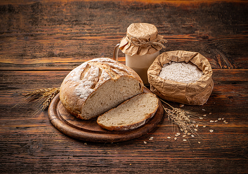 Artisan sliced sourdough bread on wooden background