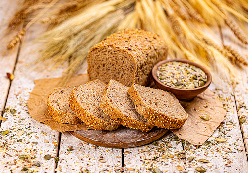 Loaf of bread with seeds on wooden background