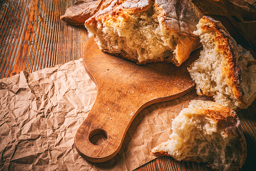 Broken pieces of bread on wooden table