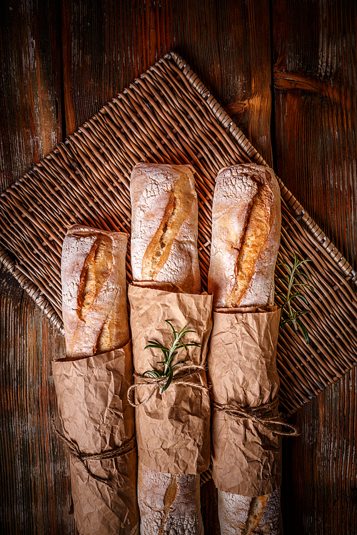 Top view of traditional white baguettes on wood background