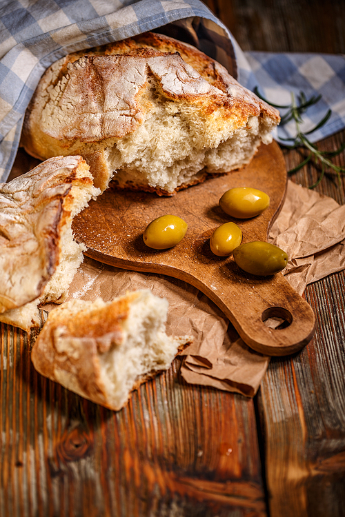 Broken pieces of bread on wooden table