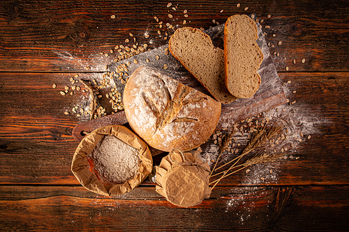 Above view of a rustic loaf of bread on an old wooden table.