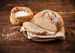 Delicious freshly baked bread on wooden background