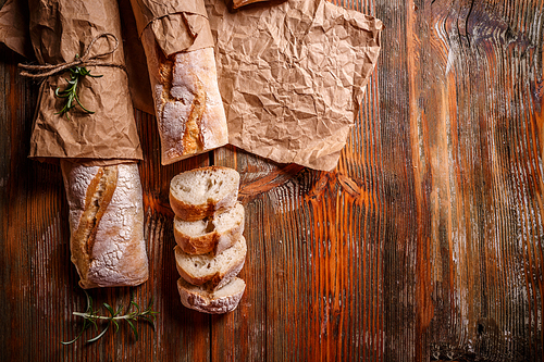 Top view of freshly baked French baguettes on old wooden background