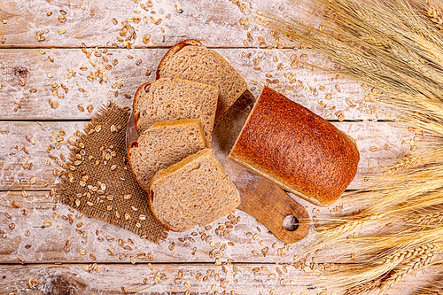 Top view of sliced wholegrain bread on wooden background