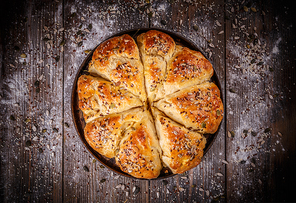 Bread buns with various seeds on vintage wooden table