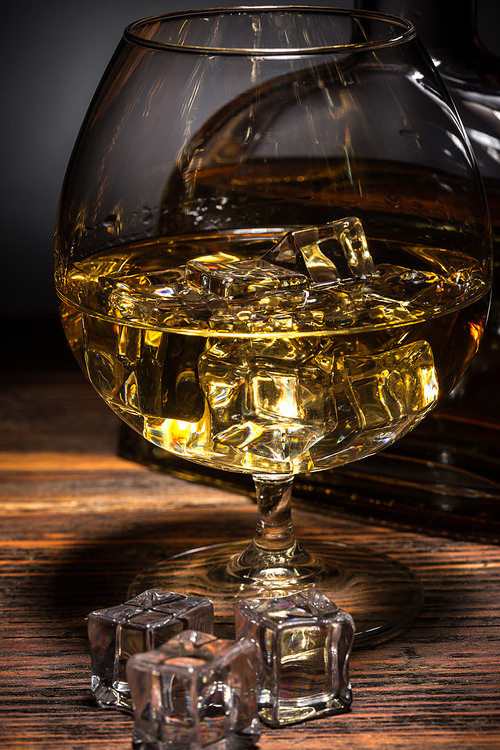 Close up of cognac in glass with ice cube